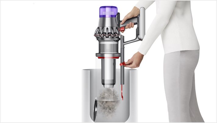 Woman emptying Dyson Outsize vacuum into bin Woman emptying Dyson Outsize vacuum into bin